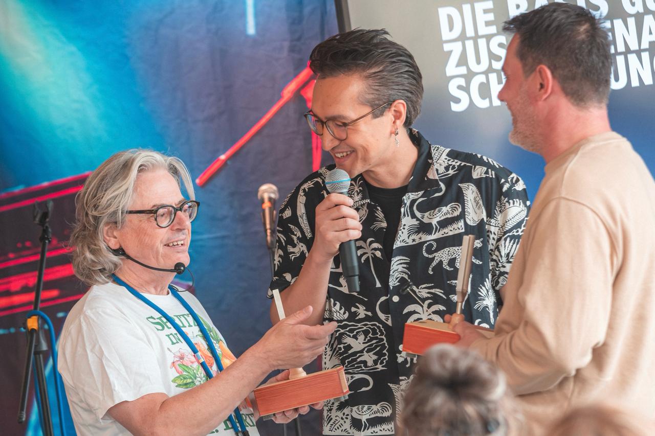 René Rennefeld überreicht einen Rock Your Role Award auf der Bühne