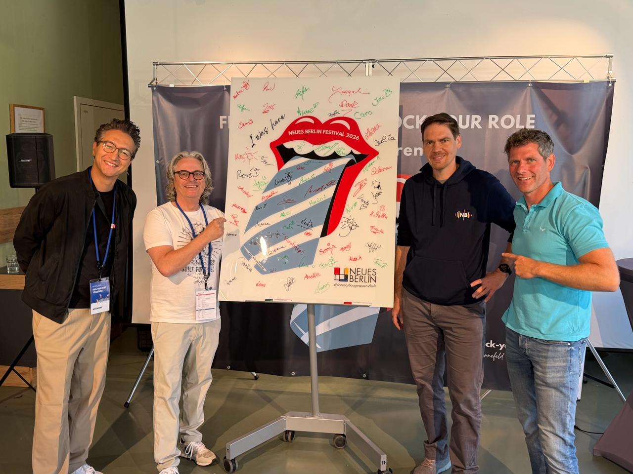 Team posiert mit dem von allen Teilnehmenden signierten Rock Your Role Poster beim Neues Berlin Festival